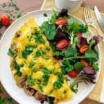 Savory spinach mushroom omelet filled with sautéed mushrooms, wilted spinach, and melted Gruyère in a nonstick skillet.