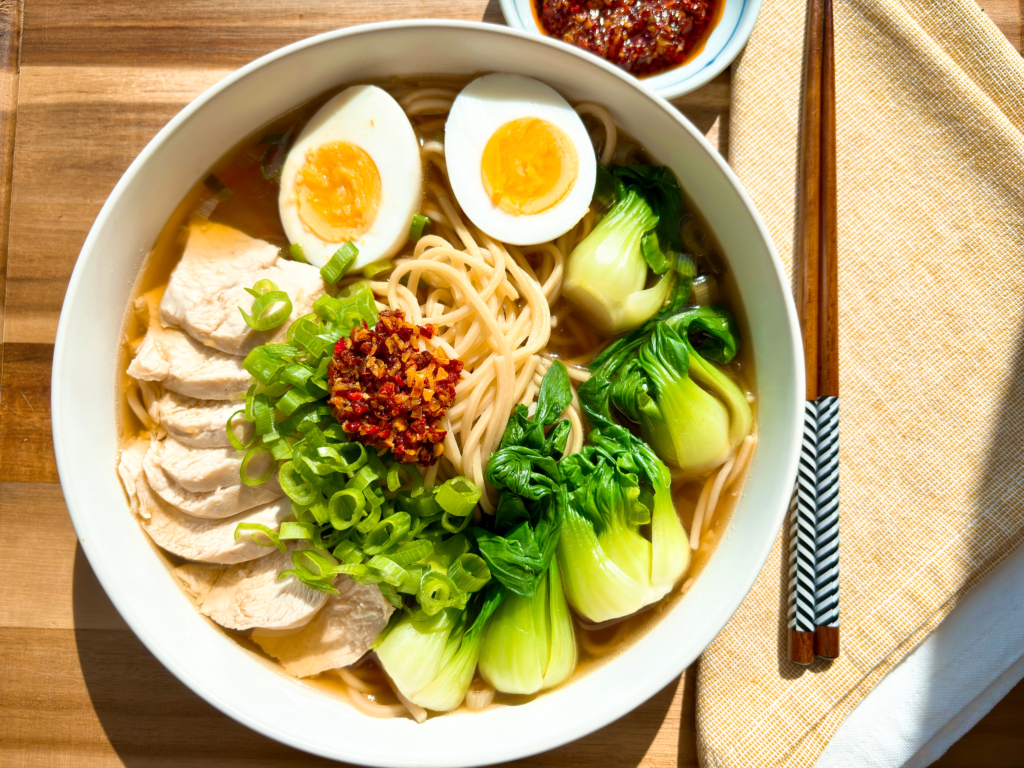 Bowl of easy chicken ramen made with Swanson® Ramen Broth, bok choy, scallions, sliced chicken, and jammy egg.