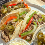 Cheesesteak and peppers tortilla wrap with melted Swiss and Gruyere cheese, sautéed onions, and colorful bell peppers in a soft tortilla — a healthy high-protein take on a Philly cheesesteak wrap.