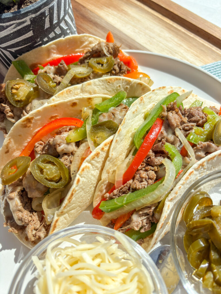 Cheesesteak and peppers tortilla wrap with melted Swiss and Gruyere cheese, sautéed onions, and colorful bell peppers in a soft tortilla — a healthy high-protein take on a Philly cheesesteak wrap.
