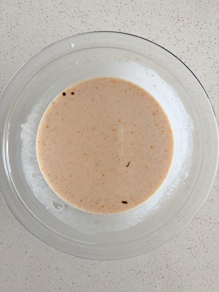 Greek yogurt whisked with hot broth in a glass bowl to keep the soup from curdling.