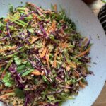 Crunchy Thai quinoa salad with purple cabbage, thinly sliced snow peas, carrots, and creamy peanut dressing