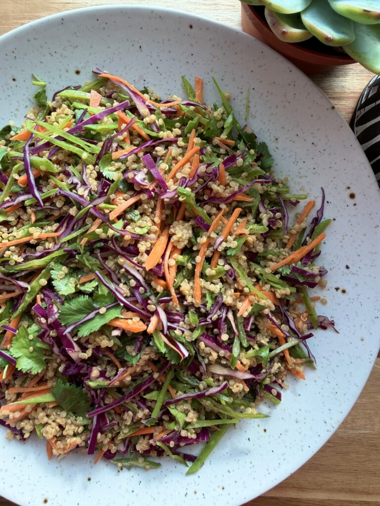 Crunchy Thai quinoa salad with purple cabbage, thinly sliced snow peas, carrots, and creamy peanut dressing