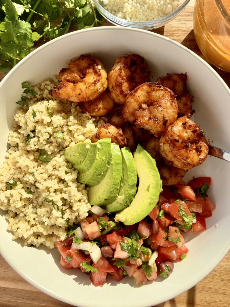 Chili-lime shrimp bowl with lime-cilantro quinoa, pico de gallo with black beans, avocado, cotija, and creamy chipotle ranch