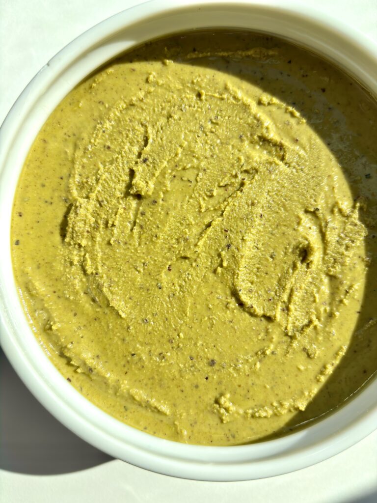 Creamy homemade pistachio butter in a white bowl, naturally sweet and ultra smooth