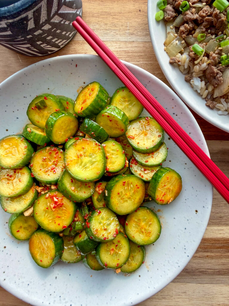 Crunchy Korean spicy cucumber salad (oi muchim) made with gochugaru, sesame oil, and scallions served in a bowl.