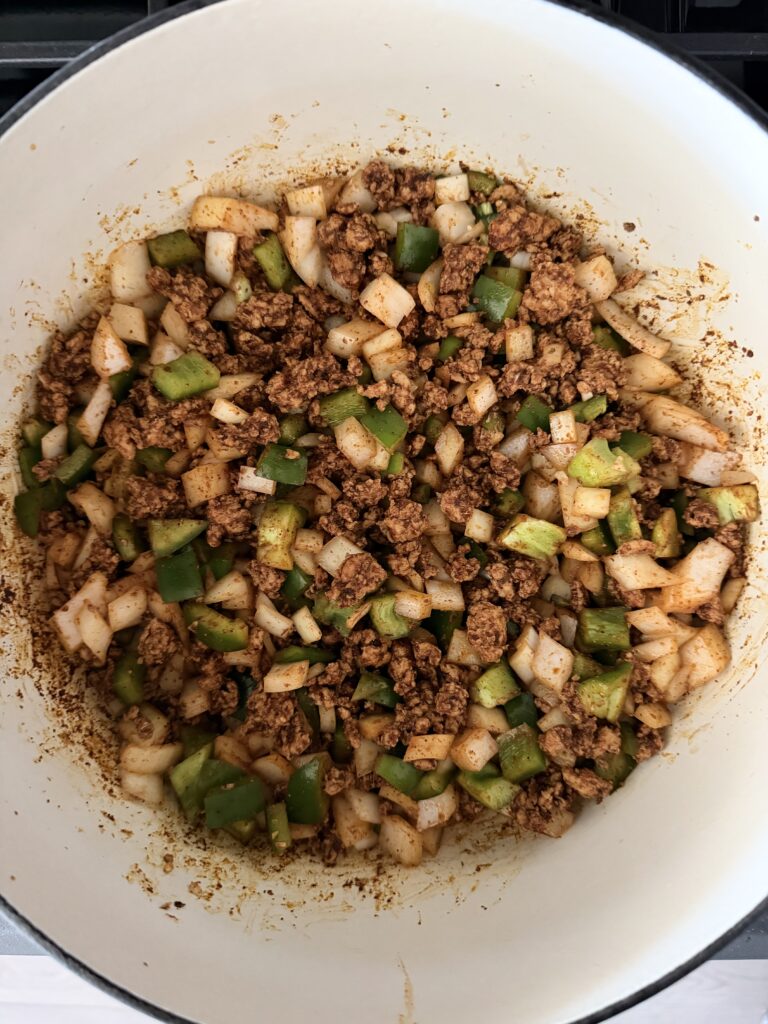 Onion, garlic, jalapeño, and green bell pepper sautéing with ground chicken