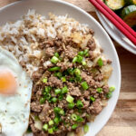 Plated Korean ground beef bulgogi topped with scallions and a fried egg