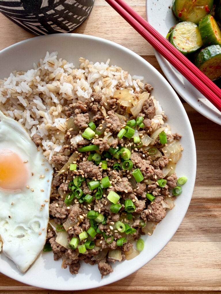 Plated Korean ground beef bulgogi topped with scallions and a fried egg