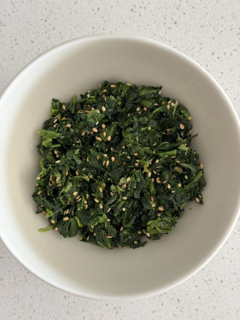 Cooked spinach squeezed dry and mixed with sesame oil, salt, and sesame seeds for a savory oatmeal bowl