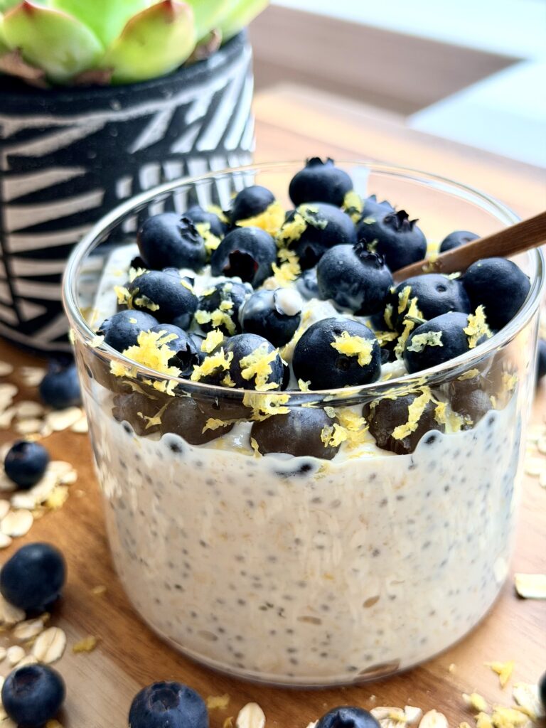 Blueberry lemon cheesecake overnight oats in a jar topped with blueberries, chia seeds, and hemp hearts