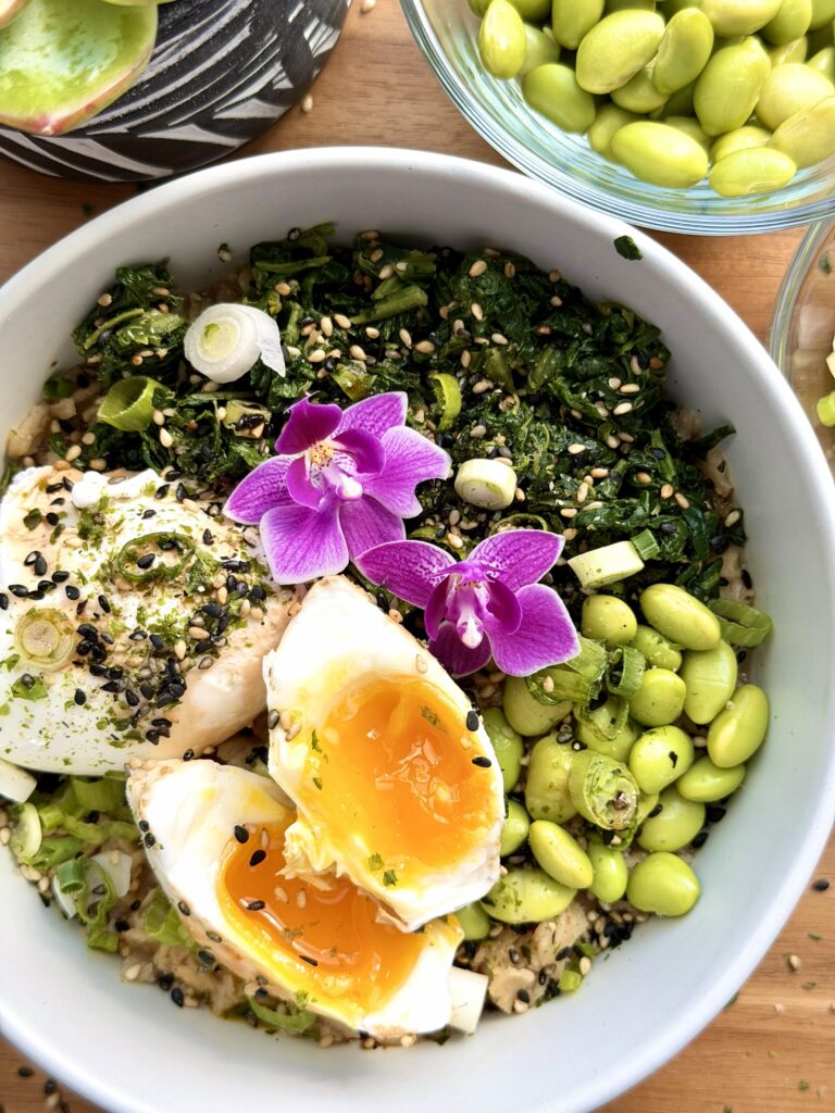 Savory oatmeal bowl with soft-boiled eggs, spinach, edamame, soy sauce, and furikake