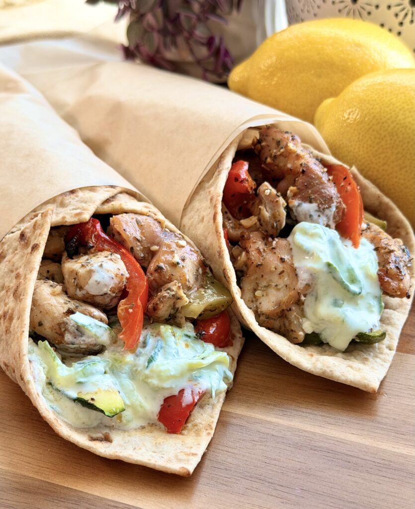 Mediterranean chicken wrap filled with roasted chicken, vegetables, feta cheese, and homemade tzatziki