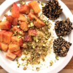 Peach Greek yogurt bowl with hemp hearts, ground flaxseed, fresh peaches, roasted pistachios, honey, and Healthy Black Sesame Seed Crackers.