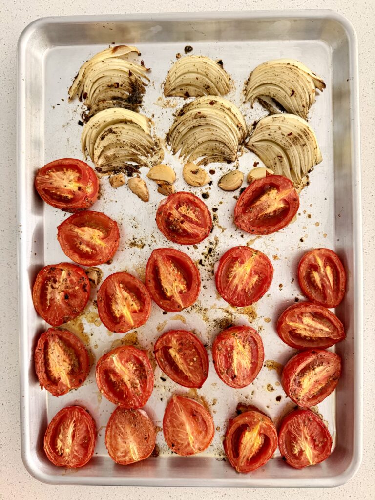 Roasted plum tomatoes, onion, and garlic caramelized on a baking sheet for white bean soup
