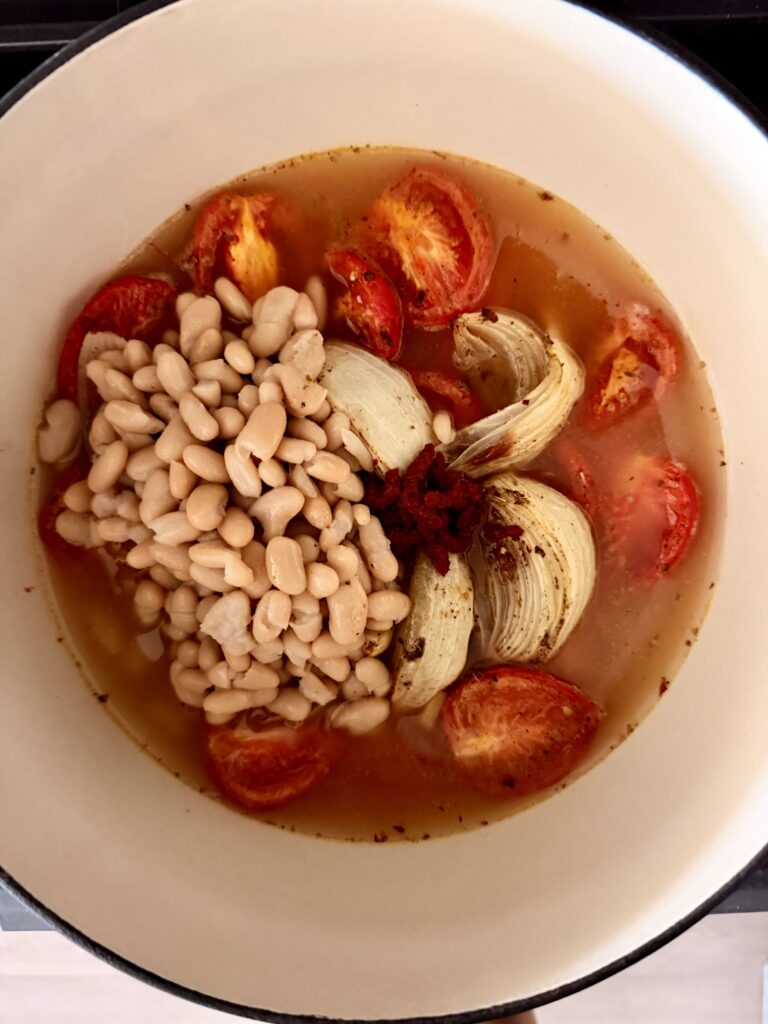Roasted tomatoes, onion wedges, and garlic transferred to a large pot to start the soup